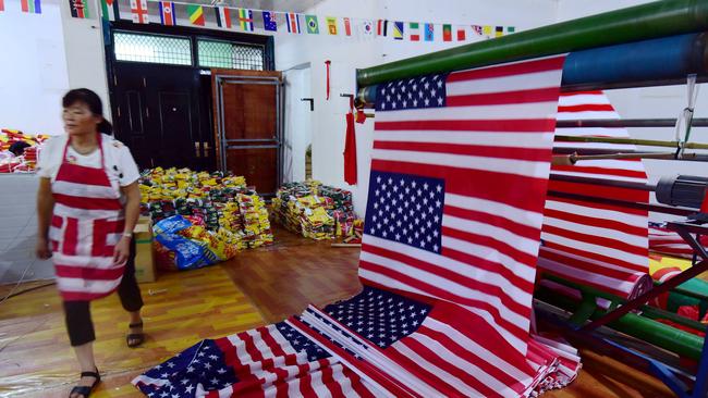 An employee walks past newly made US flags at a factory in China's eastern Anhui province. America still may be the source of most of the best ideas, but more and more of them end up taking form somewhere else. Picture: AFP