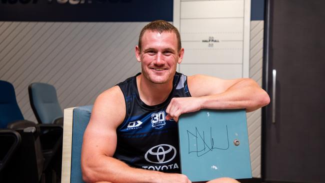 Cowboys player Coen Hess with his signed locker door which will go up for auction as part of the Cowboys Community Foundation's Christmas Auction.