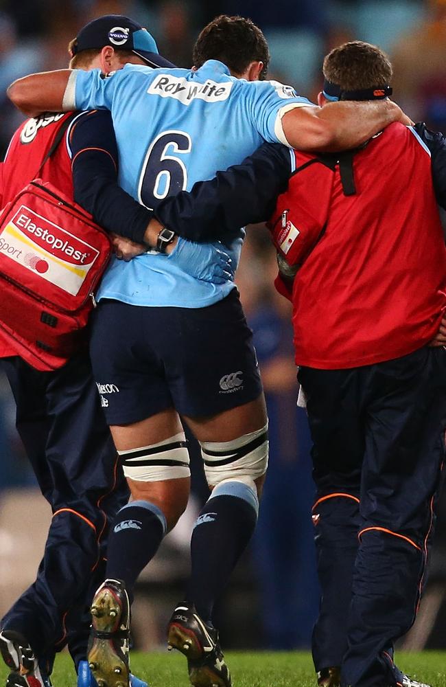 Waratahs captain Dave Dennis is taken from the field after injuring his knee.