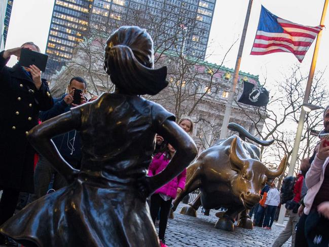 'The Fearless Girl' statue is seen facing the iconic Wall Street charging bull statue as part of a campaign to push companies to add women on their boards, on March 8, 2017, in Lower Manhattan, New York.  / AFP PHOTO / EDUARDO MUNOZ ALVAREZ