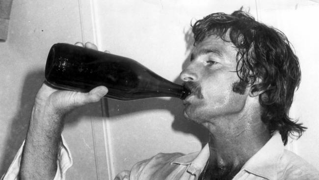 Dennis Lillee cools down from a long day in the field with a beer.