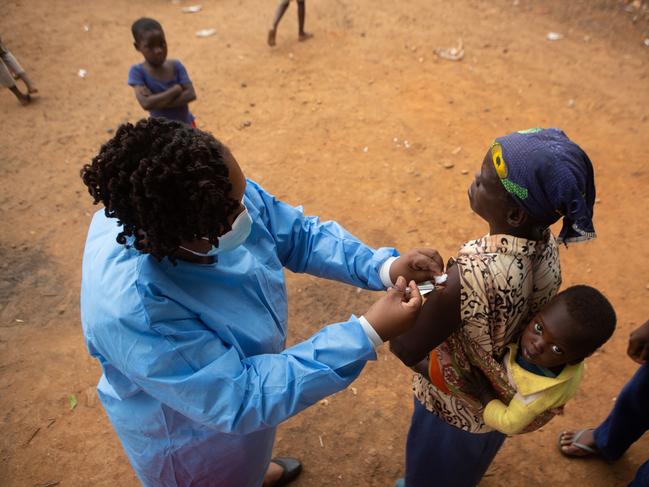 A woman gets vaccinated with an infant on her back at a shopping centre near Buwi Secondary School in Zimbabwe. Picture: Tafadzwa Ufumeli/Getty Images