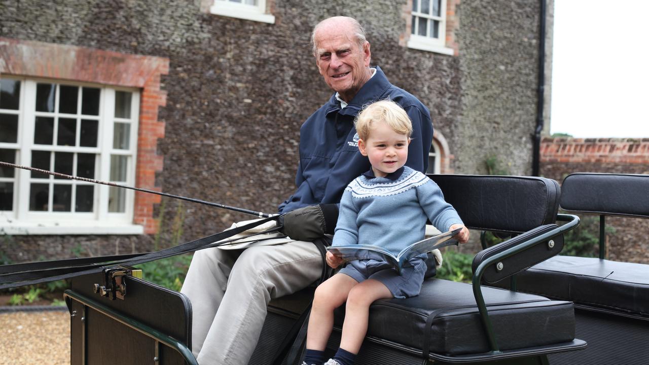 Prince George of Cambridge sits next his great-grandfather Prince Philip, Duke of Edinburgh on a horse carriage in a photograph taken by Catherine, Duchess of Cambridge in 2015 in Norfolk. Picture: The Duchess of Cambridge via Getty Images