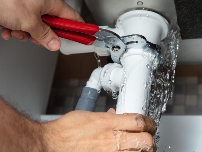 Close-up Of Male Plumber Fixing White Sink Pipe With Adjustable Wrench istock