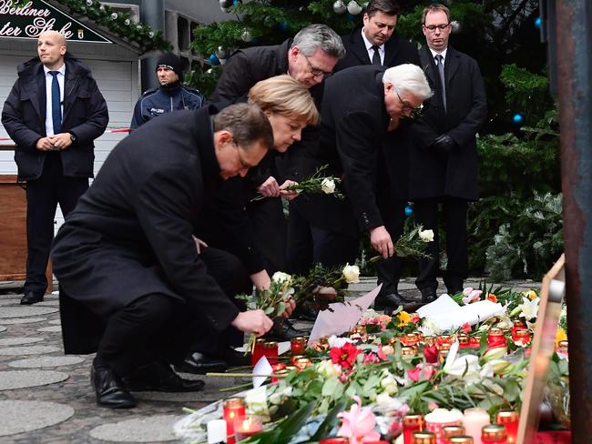 Berlin Mayor Michael Mueller, German Chancellor Angela Merkel, German Interior Minister Thomas de Maiziere and German Foreign Minister Frank-Walter Steinmeier lay flowers at a makeshift memorial for the victims of the Berlin attack. Picture: AFP