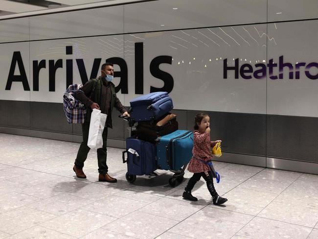 People arrive at Heathrow's Terminal 5 in west London on November 30, 2021 as new restrictions on travellers are introduced. - All passengers entering the UK are advised from Tuesday to take a PCR test for Covid-19 two days after their arrival, and to self-isolate until the receive a negative result. (Photo by Adrian DENNIS / AFP)