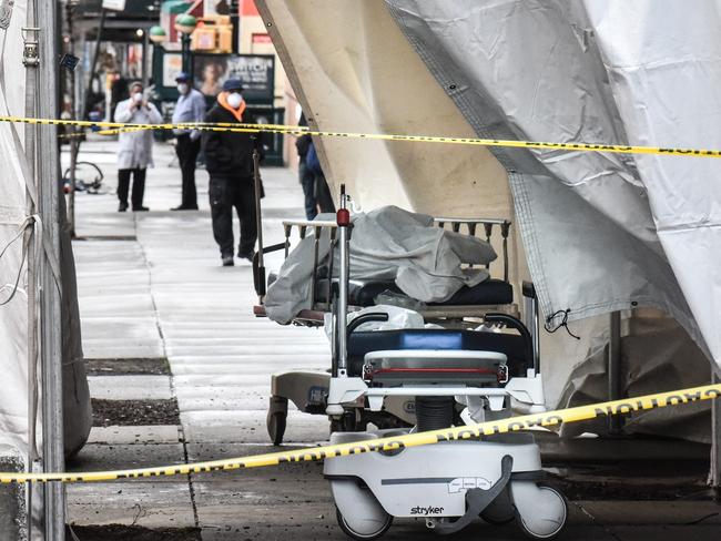 Medical workers move a body from a sidewalk in New York. Picture: AFP