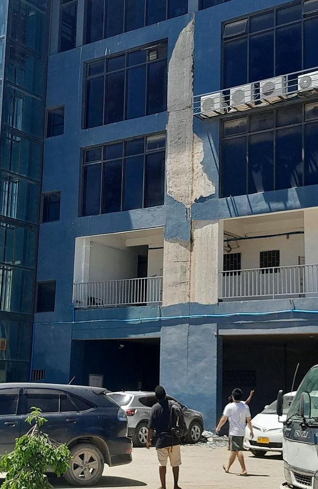 Residents outside a building checking damage done by the earthquake in Honiara. Picture: AFP.