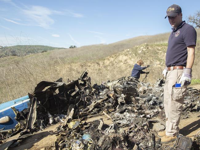 The National Transportation Safety Board, NTSB investigators Adam Huray, right, and Carol Hogan examine wreckage as part of the investigation of a helicopter crash near Calabasas. Picture: AP