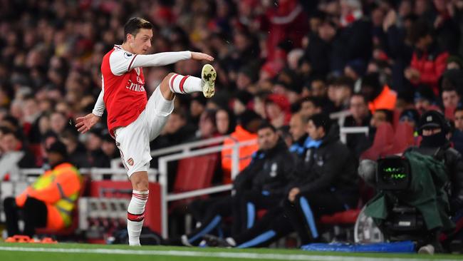 Arsenal midfielder Mesut Ozil reacts to his substitution by kicking his gloves along the touchline at the Emirates Stadium in London