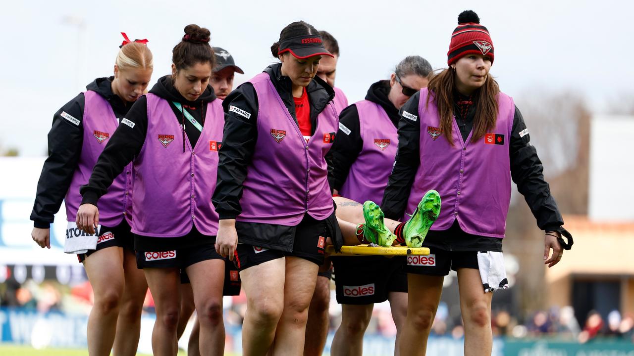 MELBOURNE, AUSTRALIA - AUGUST 31: Amber Clarke of the Bombers leaves the field on a stretcher during the 2024 AFLW Round 01 match between the Essendon Bombers and the Fremantle Dockers at Windy Hill on August 31, 2024 in Melbourne, Australia. (Photo by Michael Willson/AFL Photos via Getty Images)