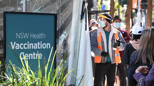 People queue to receive the COVID-19 vaccine at the New South Health Vaccination Centre at Sydney Olympic Park. (Photo by James D. Morgan/Getty Images)