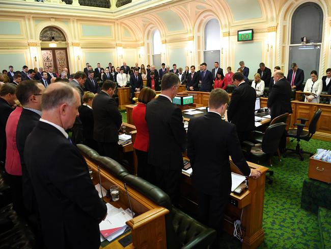 Queensland Members of Parliament stand for a minute silence during a condolence motion for the late Terry Mackenroth during a Legislative Assembly session at Parliament House in Brisbane, Friday, June 15, 2018. Mr Mackenroth, a former Labor deputy premier and treasurer, died at the age of 68 in April after a short battle with lung cancer. (AAP Image/Dan Peled) NO ARCHIVING