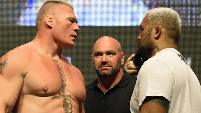 UFC President Dana White (C) looks on as Brock Lesnar (L) and Mark Hunt (R) face off.