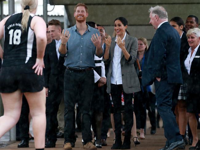 Prince Harry and Meghan smile through a downpour while visiting Dubbo College Senior Campus. Picture: Toby Zerna