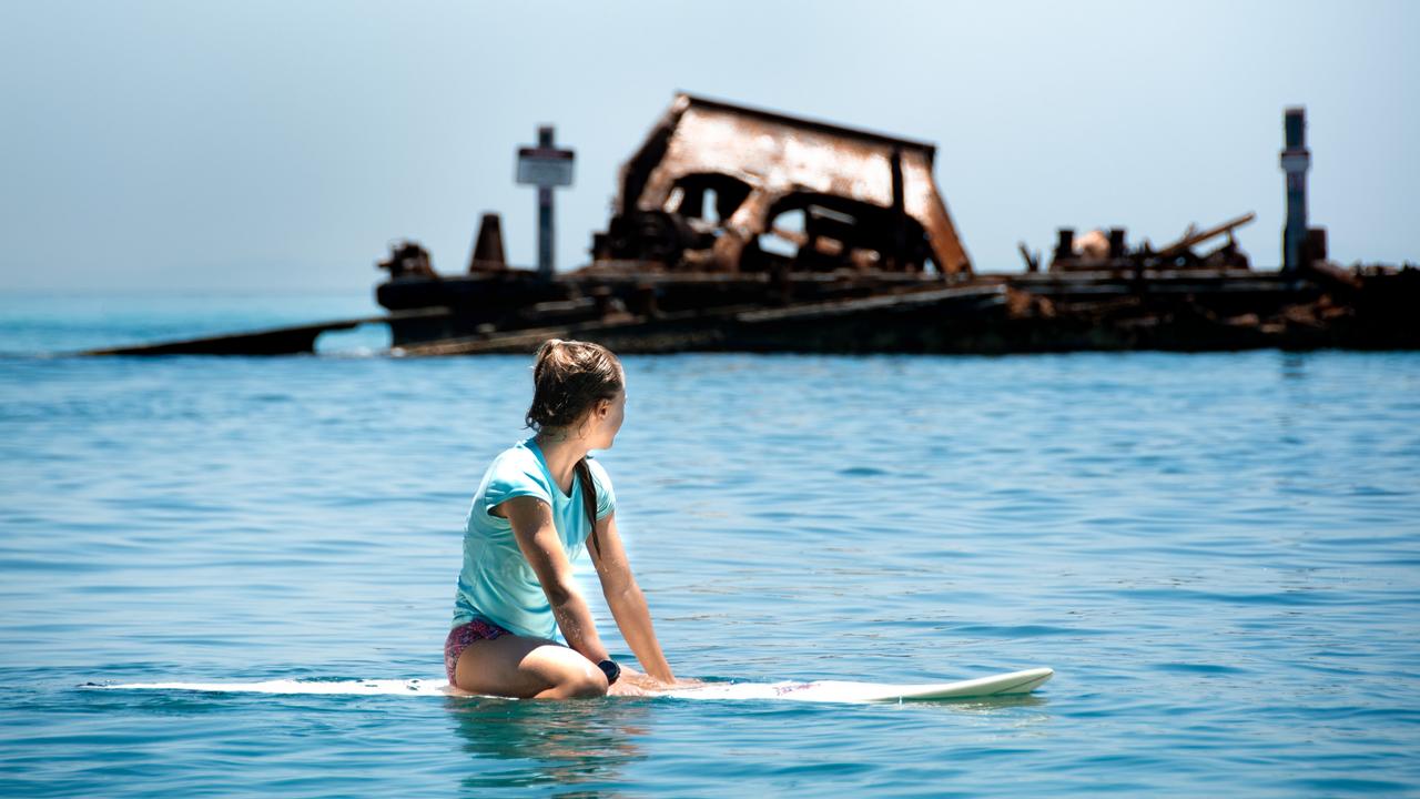 A tourist paddles surveys the wrecks at Tangalooma. Courtesy: TEQ