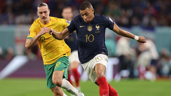 France's forward #10 Kylian Mbappe (R) evades Jackson Irvine.