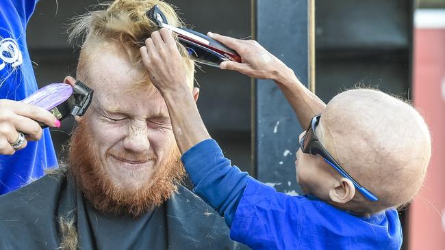 Midway through Enzo Cornejo shaving Josh Scott’s hair at St Mary’s Memorial School. Picture: AAP/Roy VanDerVegt