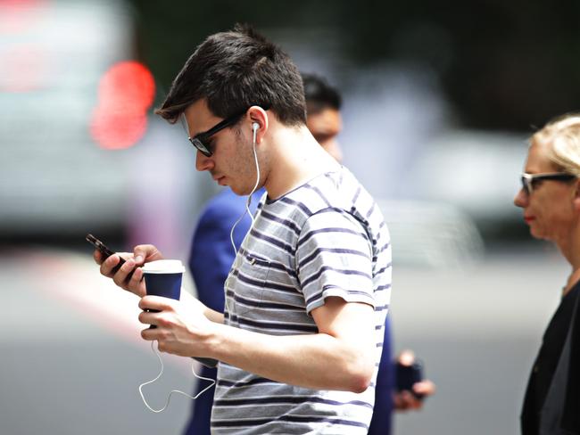 22/12/16 People looking down at their phones while the cross the road on Elizabeth St in Martin place. Adam Yip/ The Daily Telegraph