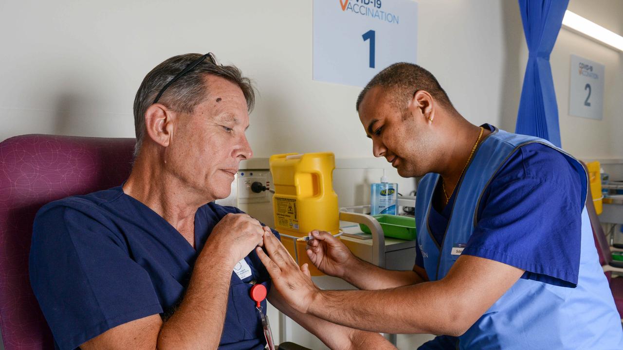 Registered nurse Subash Chapagai gives Queen Elizabeth Hospital Emergency Department Nursing Unit manager Chris McCaskill a AstraZeneca shot. Picture: Brenton Edwards/NCA NewsWire