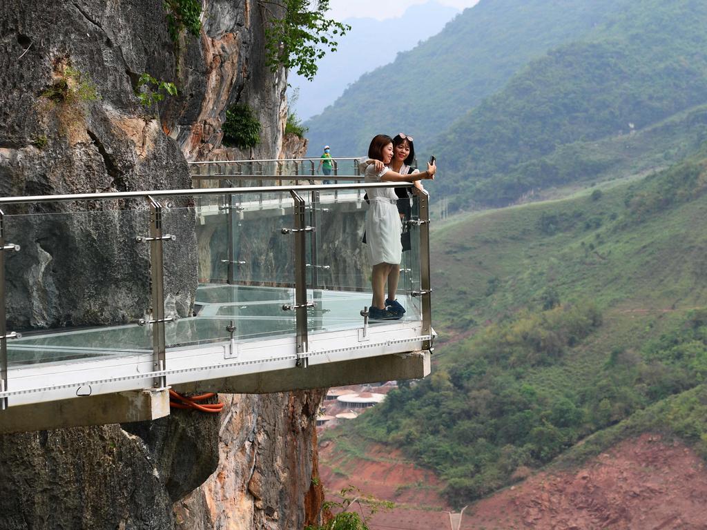 Visitors take photos on the walkway section that hugs the cliffs above the gorge. Picture: Nhac Nguyen/AFP