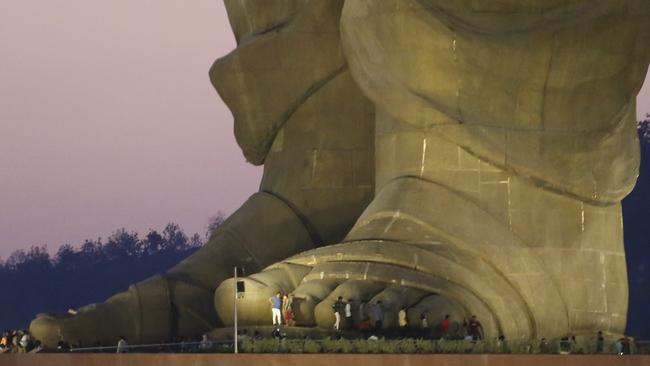 Visitors stands near the feet of the Statue of Unity. Picture: Ajit Solanki/AP