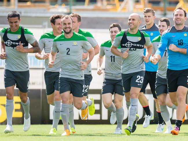 Half the Socceroos squad go through their warm-up routine.