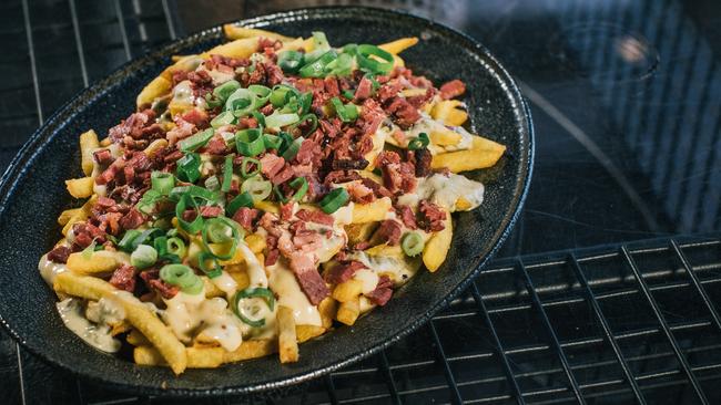 The pastrami fries from Ze Pickle — pieces of house smoked pastrami topped with cheese and spring onion.