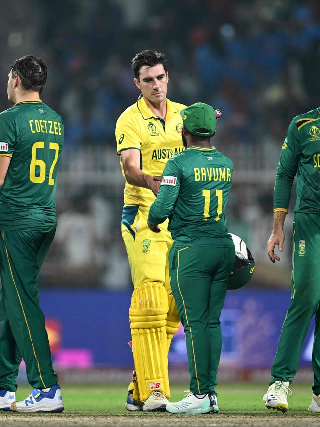 Australia's captain Pat Cummins shakes hands with his South Africa counterpart Temba Bavuma. Photo by DIBYANGSHU SARKAR / AFP.