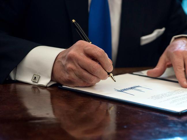 Donald Trump signs an executive order in 2017 reviving the construction of two controversial oil pipelines, including the Keystone XL pipeline. Picture: AFP