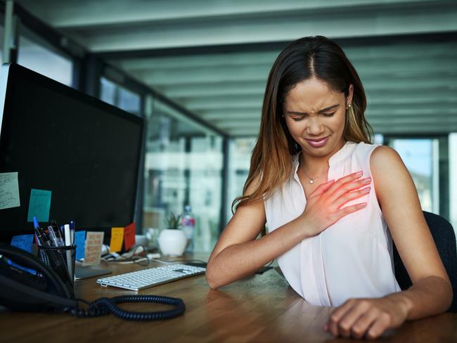 Shot of a young businesswoman suffering with chest pain while working in an office