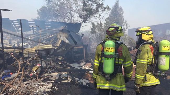 A clean-up crew survey the remains of a building at Bomaderry.