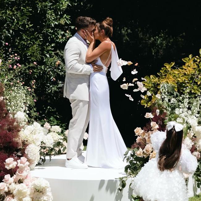 Kayla Itsines and Jae Woodroffe, and flower girl Arna, surrounded by floral arrangements by Adelaide Flower House. Picture: Instagram