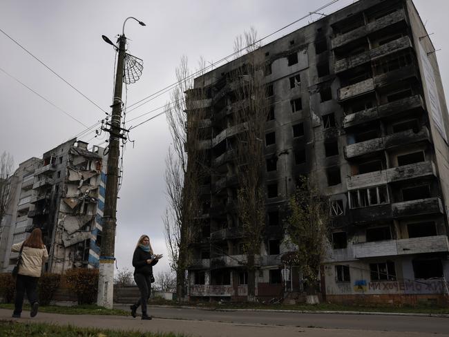 Members of the public walk past destroyed buildings in Borodyanka, Ukraine. Picture: Getty Images