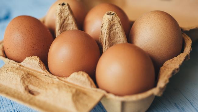 Eggs background. Closeup view of eggs in carton box on wooden table. Food and health concept.  Picture: istock