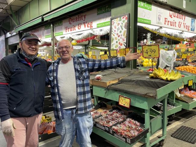 Fernando with his co-worker at MnM Fruit Shop in the Preston market as the stacked fruit at the stall in preparation for the day. Picture: Olivia Condous