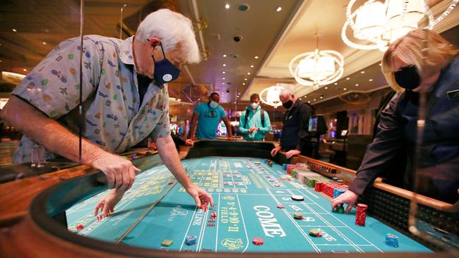 Gene Koonce, from Colorado, plays craps at the reopening of the Bellagio casino. Picture: Ronda Churchill