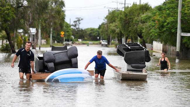 Local residents use a boat and an inflatable pool to salvage furniture from their flood-affected home in the suburb of Hermit Park in Townsville, Wednesday, February 6, 2019. Residents have begun cleaning up after days of torrential rain and unprecedented water releases from the city's swollen dam, sending torrents of water down the Ross River and into the city, swamping roads, yards and homes. (AAP Image/Dan Peled) NO ARCHIVING