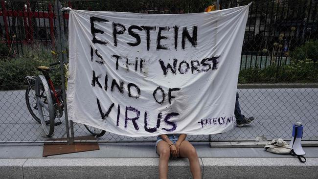 A protester sits outside the New York court where Ghislaine Maxwell appeared last week. Picture: AFP