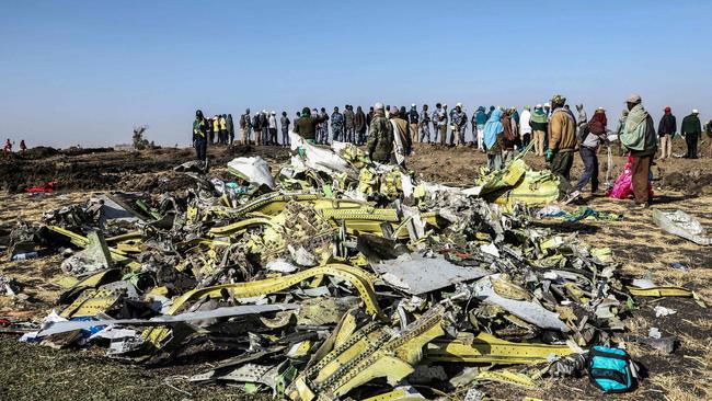 (FILES) In this file photo taken on March 11, 2019, people stand near collected debris at the crash site of Ethiopia Airlines near Bishoftu, a town some 60 kilometres southeast of Addis Ababa, Ethiopia. - A preliminary report from the fatal crash of a Boeing 737 Max in which 157 people died in Ethiopia will be released on April 1, 2019, Ethiopia's foreign ministry said. The Boeing 737 MAX 8 operated by Ethiopian Airlines crashed on March 10, southeast of Addis Ababa. (Photo by Michael TEWELDE / AFP)