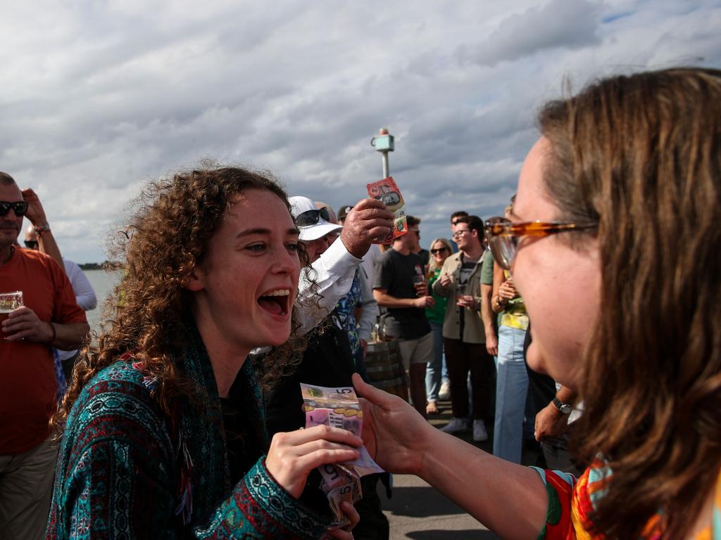 Two women get their money ready. (Photo by Roni Bintang/Getty Images)