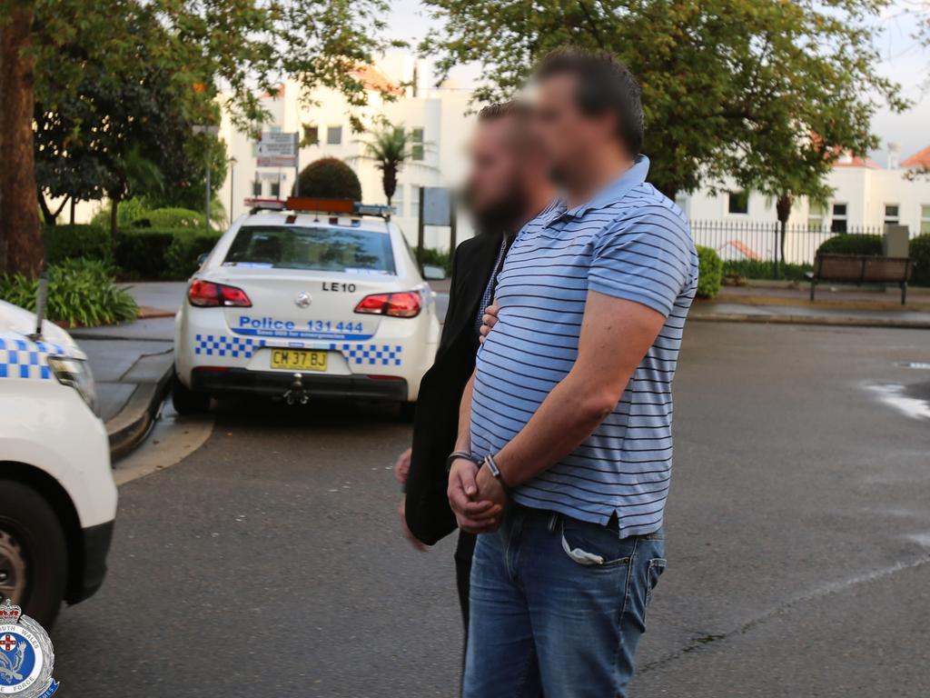 Mr Miller is led away from his home by a detective. Picture: NSW Police Force