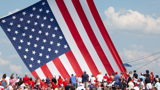 Trump supporters cheer as the American flag is untangled before former US President and Republican presidential candidate Donald Trump speaks at Butler Farm.