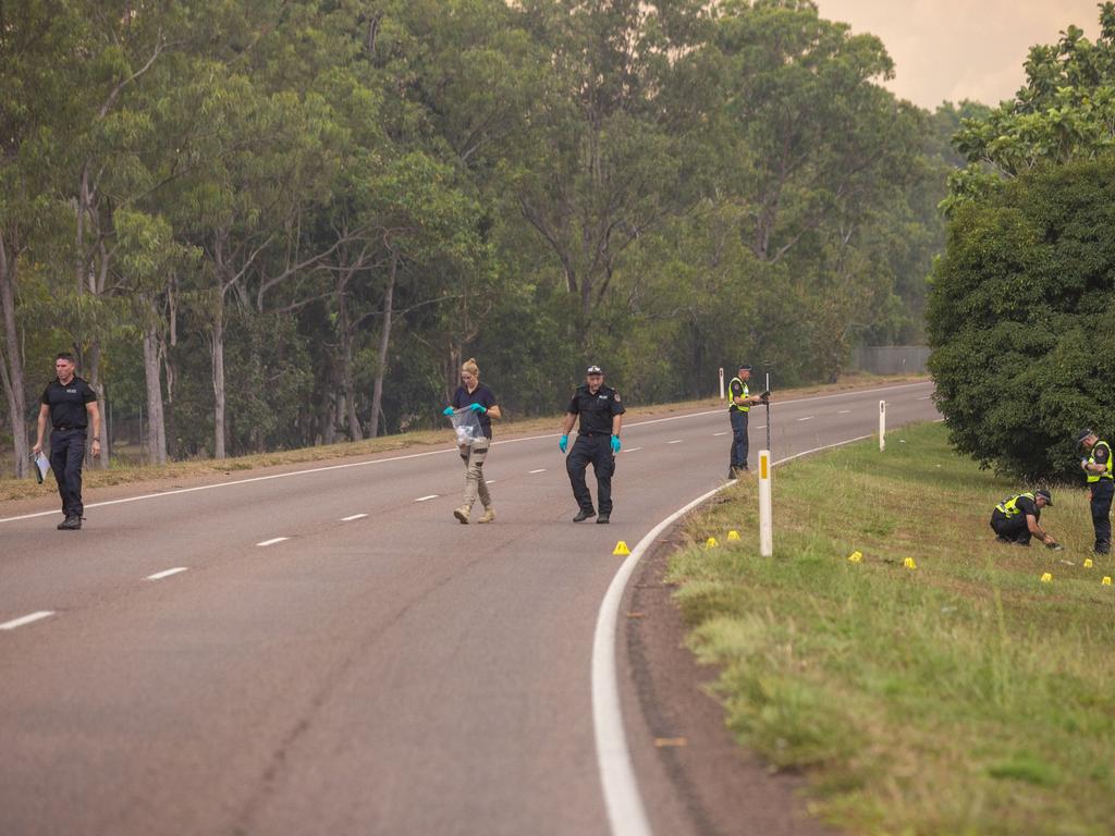 At the crime scene on the Stuart Hwy, near Coolalinga, Investigators walk away with a object in an evidence bag. Picture: Floss Adams.