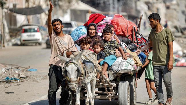 A man leads a donkey pulling a cart transporting his family as they try to return to their home in the Tuffah district east of Gaza City on Monday. Picture: AFP