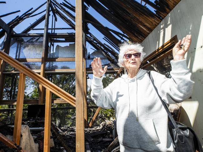 Peregian Beach resident Pam Murphy in the wreckage of her home on Plover Street which was destroyed by bushfire. Picture: Lachie Millard