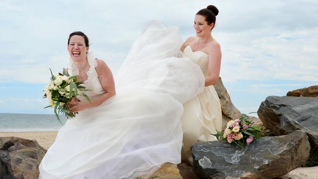 Minda employees Vanessa Hillman (white wedding dress) and Sarah Poppy (taller in cream wedding dress) at Brighton Beach. Pic: Tricia Watkinson. STORY: indaÕs reStyle Sanctury (Op Shop) has had 70 dresses donated by Caleche Bridal (approx. 50 wedding dresses and 20 mother of the bride/formal gowns) Ð some of which retail for thousands of dollars. Minda will run an event in a few weeks at reStyle Sanctuary to promote them to brideÕs to be, and all proceeds will go to supporting the people at Minda.