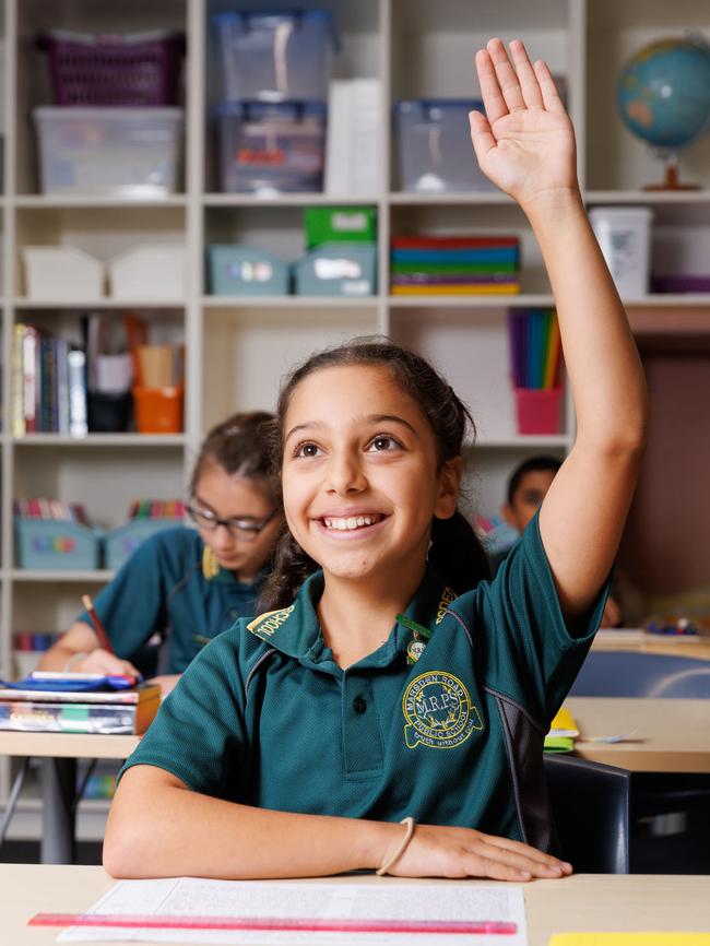 Ellie Geogiou, 11, raises her hand in class to ask a question. Student must be called upon by their teacher before they can speak. Picture: David Swift