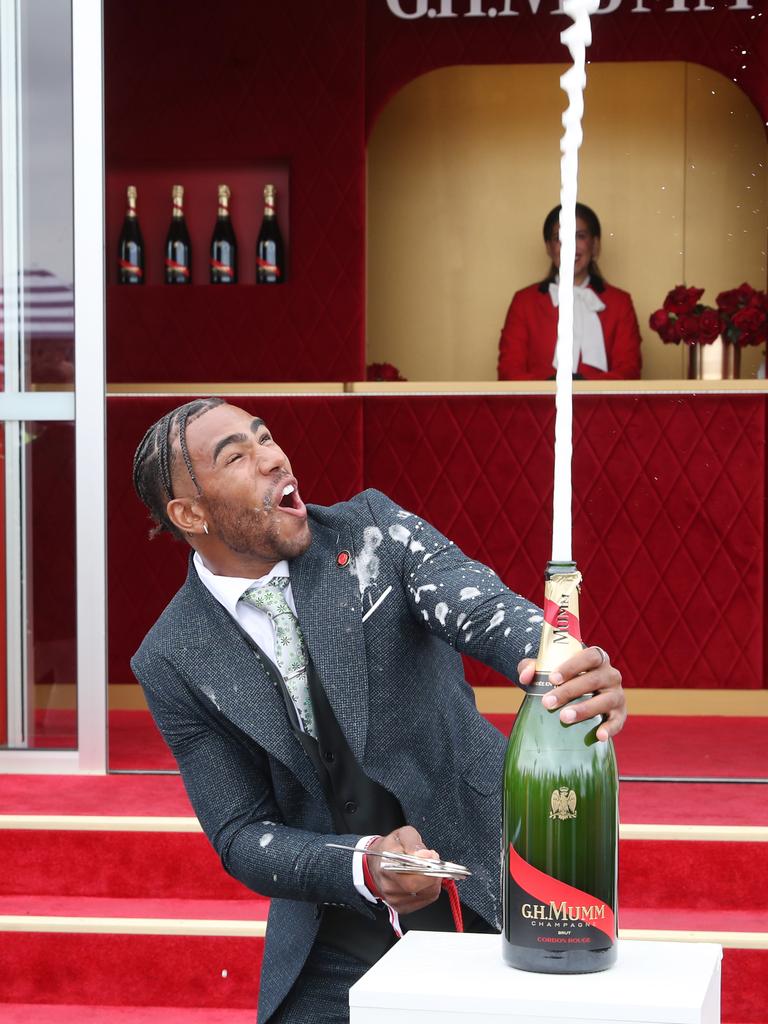 Collingwood player Isaac Quaynor cracked a bottle open at Stakes Day. Picture: NCA NewsWire / David Crosling