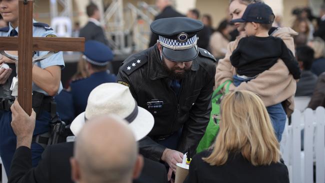 Police officers were seen lighting candles for mourners. Picture: NCA NewsWire / Monique Harmer